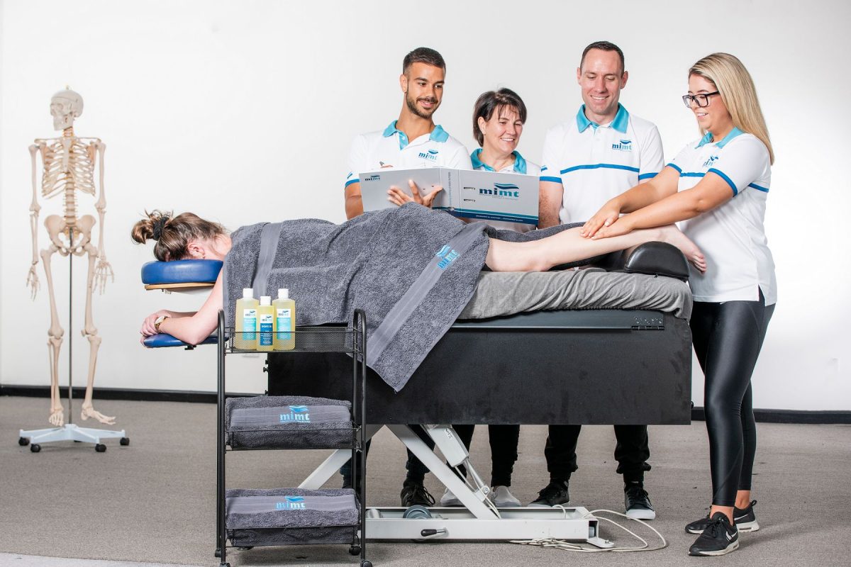 students with person lying on massage table